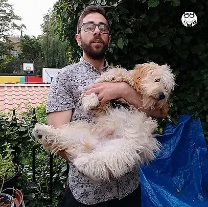 Photo of Ben holding a dog in a garden.